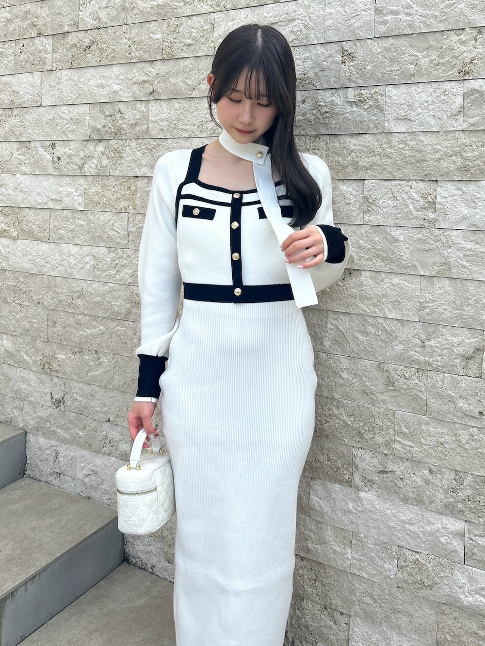 ホワイト系のワンピース、ブラック系のパンプスを着用したレディースの冬コーディネートの7枚目の写真