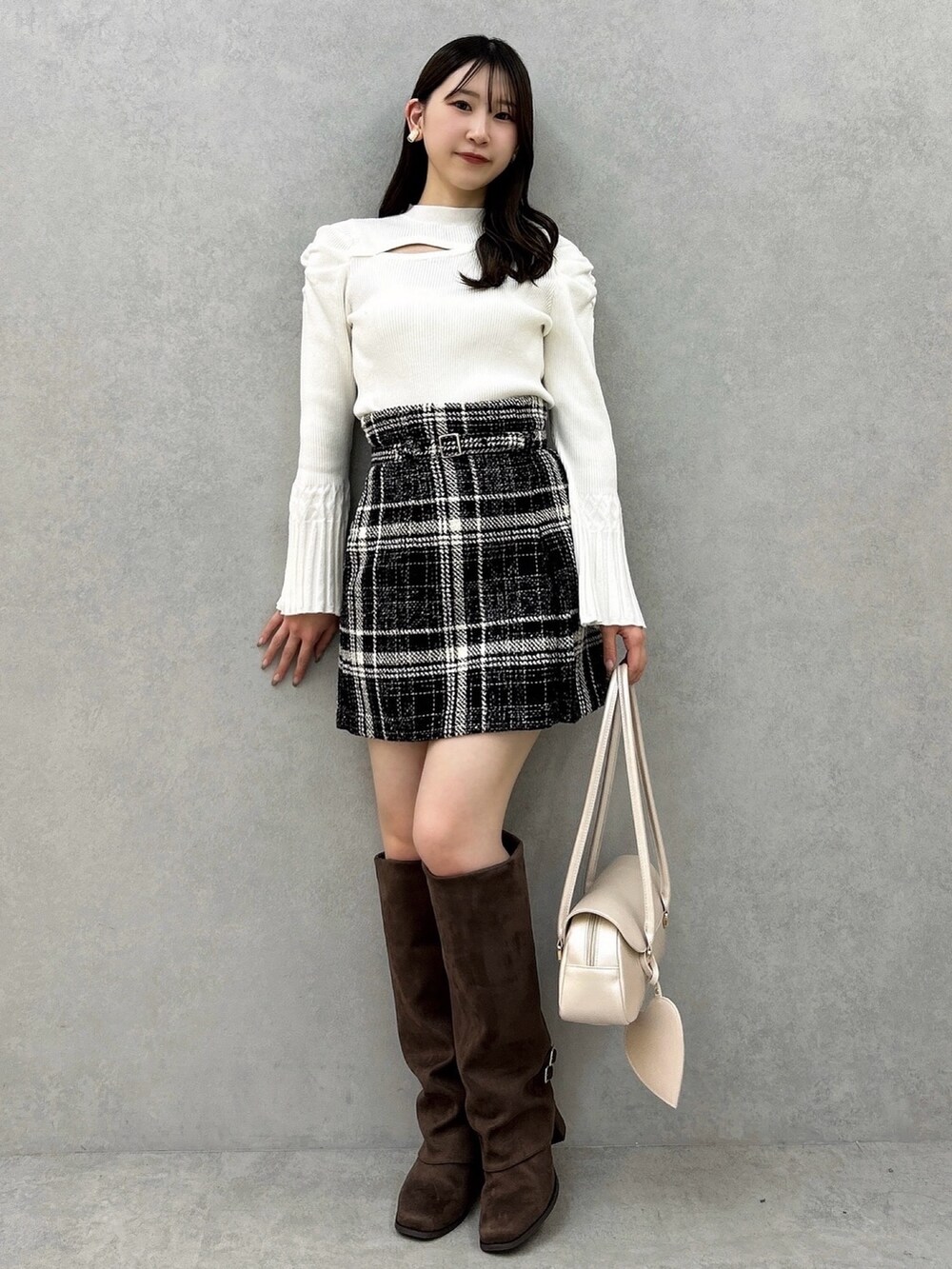 ホワイト系のニット/セーター、ブラック系のスカート、ブラック系のスカートを着用したレディースの冬コーディネートの2枚目の写真