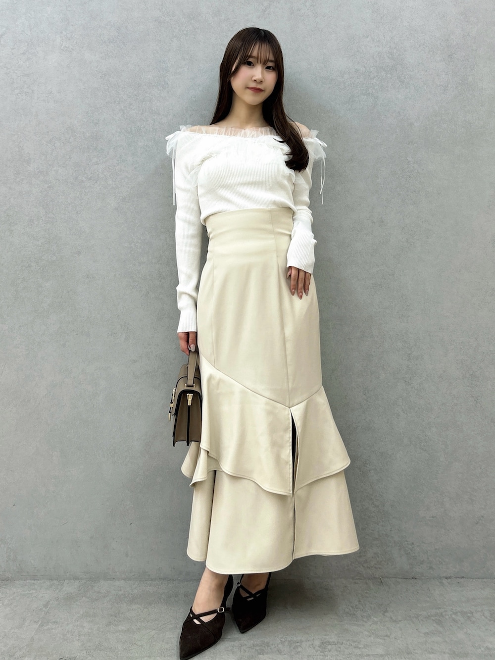 ホワイト系のニット/セーター、ホワイト系のスカート、ブラウン系のパンプスを着用したレディースの秋コーディネートの5枚目の写真