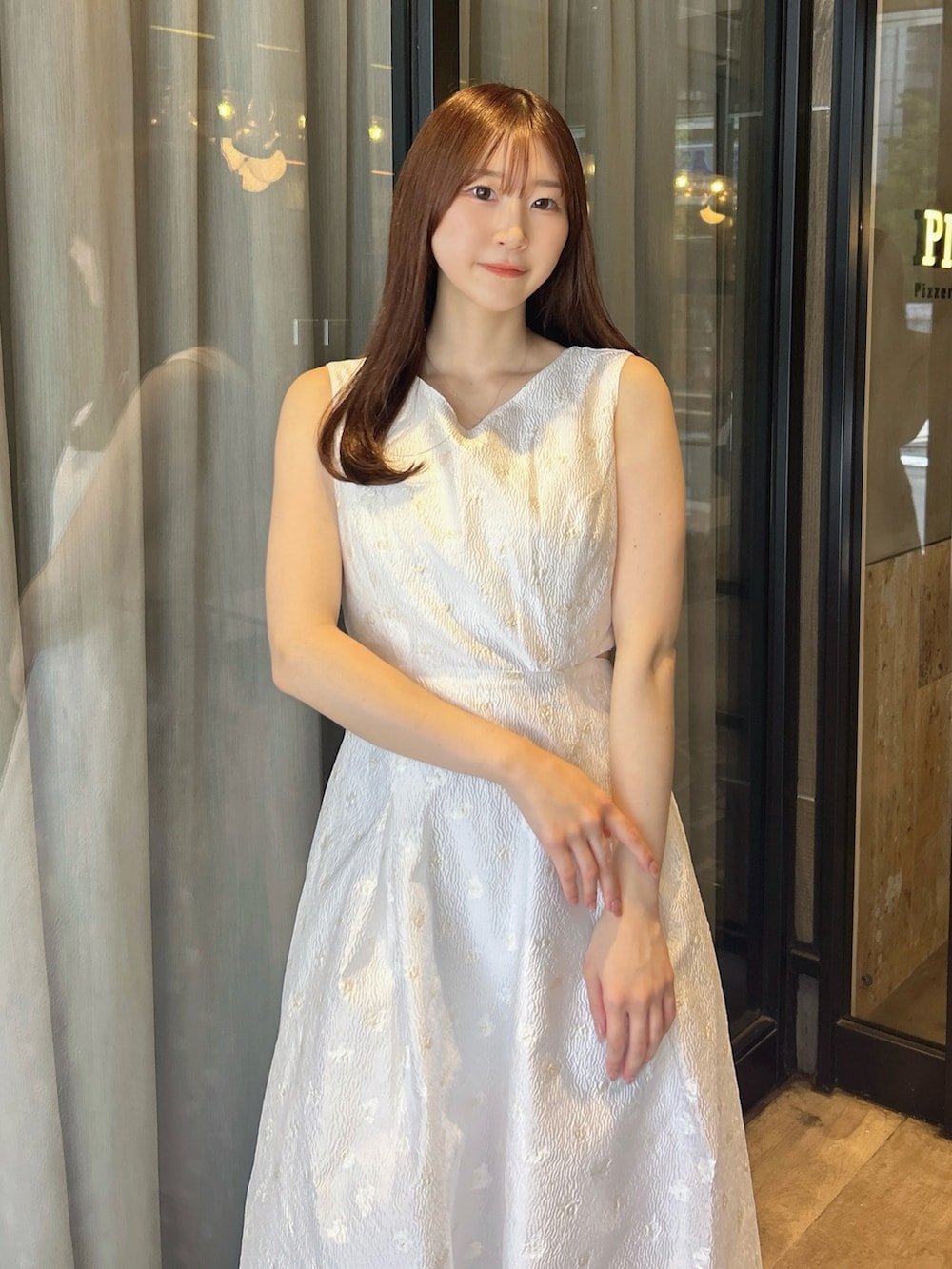 ホワイト系のワンピース、ホワイト系のサンダルを着用したレディースの秋コーディネートの6枚目の写真