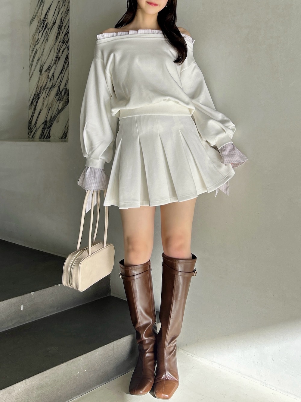 ホワイト系のTシャツ/カットソー、ホワイト系のスカート、ブラウン系のブーツを着用したレディースの春コーディネートの4枚目の写真