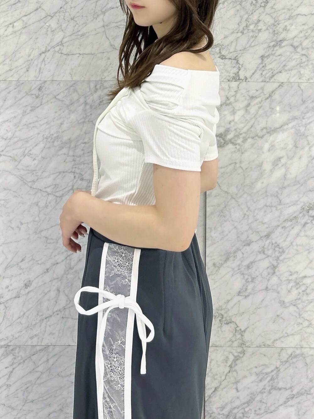 グレー系のスカート、ホワイト系のTシャツ/カットソー、ブラック系のパンプスを着用したレディースの秋コーディネートの9枚目の写真