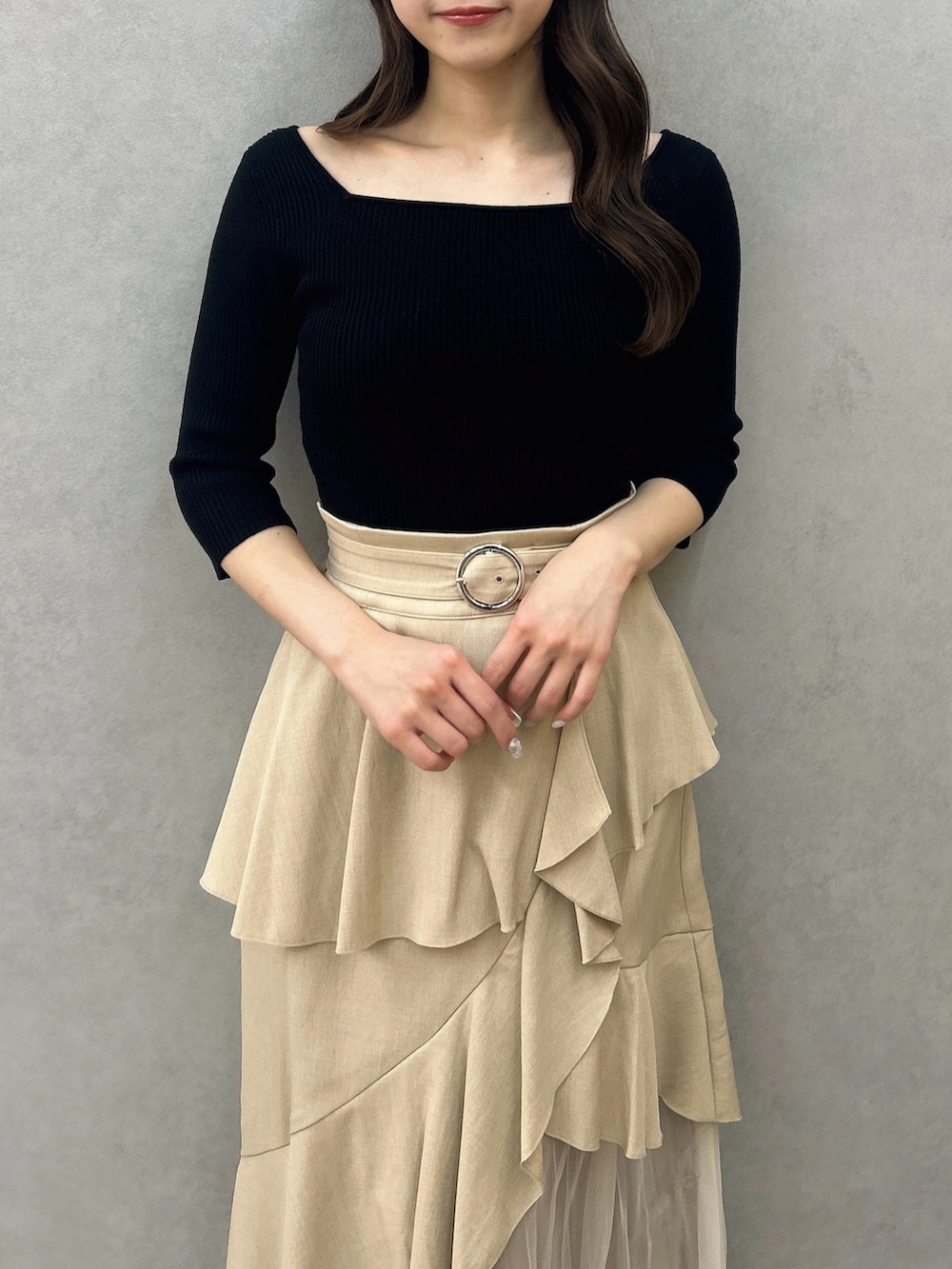 ブラック系のニット/セーター、ベージュ系のスカート、ブラック系のパンプスを着用したレディースの冬コーディネートの6枚目の写真