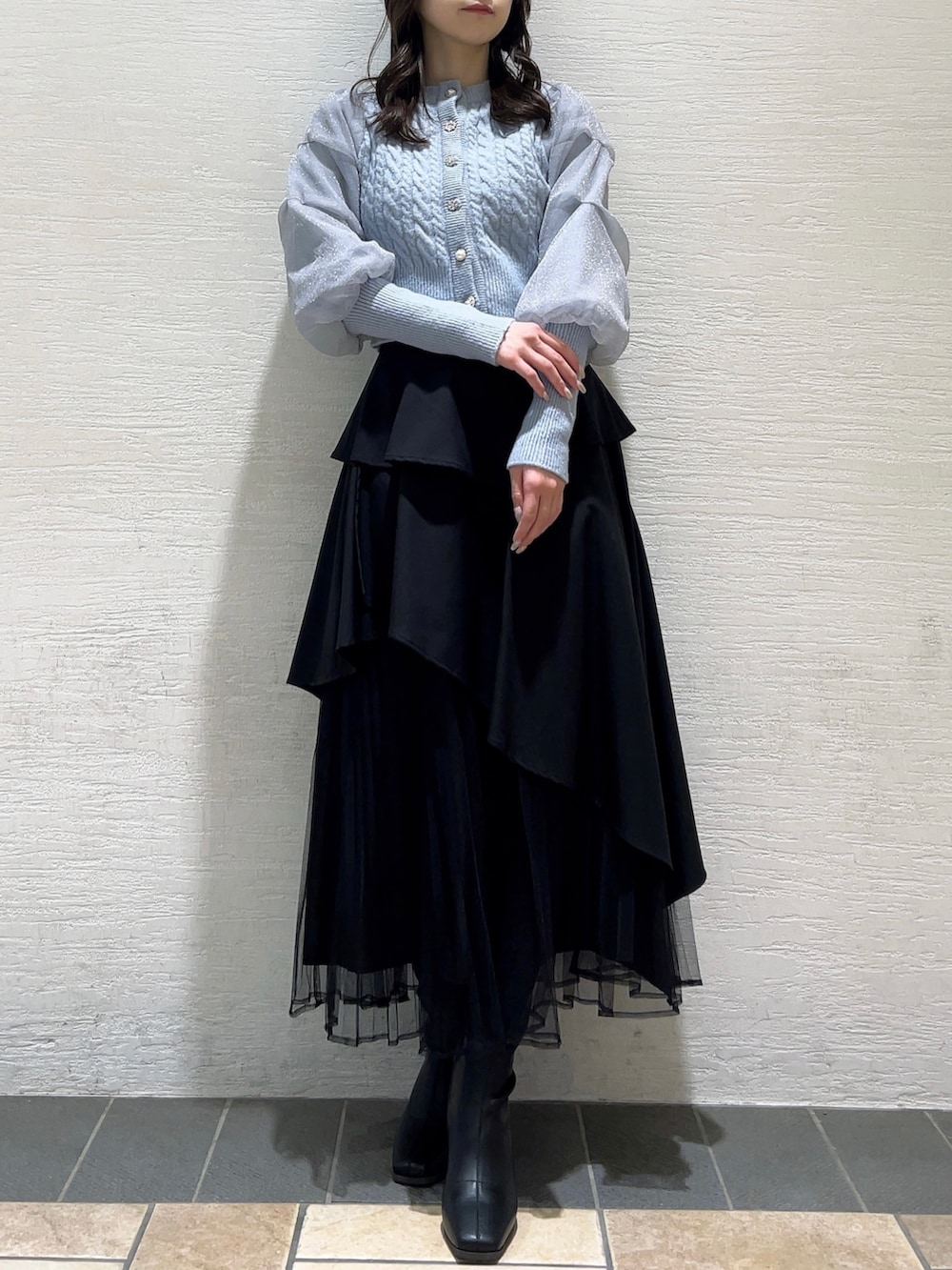 ブルー系のカーディガン/ボレロ、ブラック系のスカート、ブラック系のブーツを着用したレディースの冬コーディネートの3枚目の写真