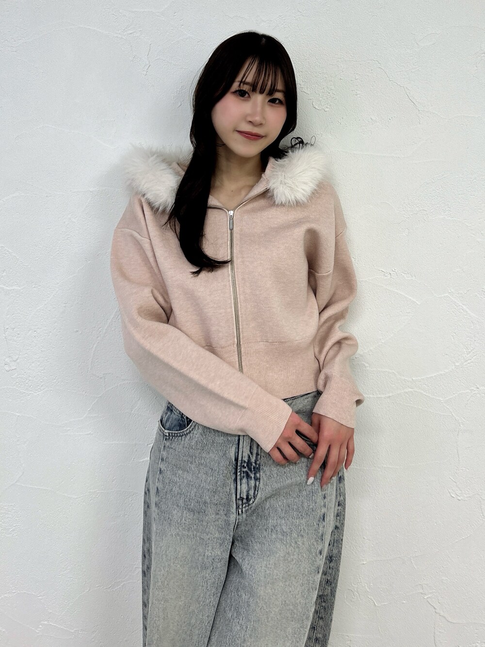 ピンク系のニット/セーター、ブルー系のデニムパンツを着用したレディースの冬コーディネートの6枚目の写真