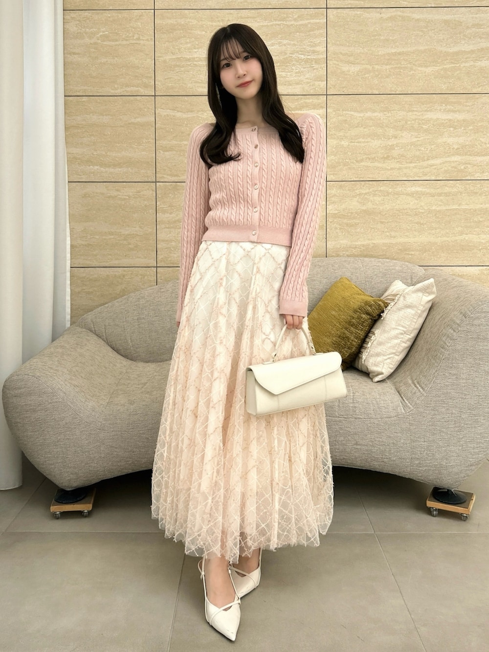 ピンク系のニット/セーター、ピンク系のスカートを着用したレディースの秋コーディネートの3枚目の写真