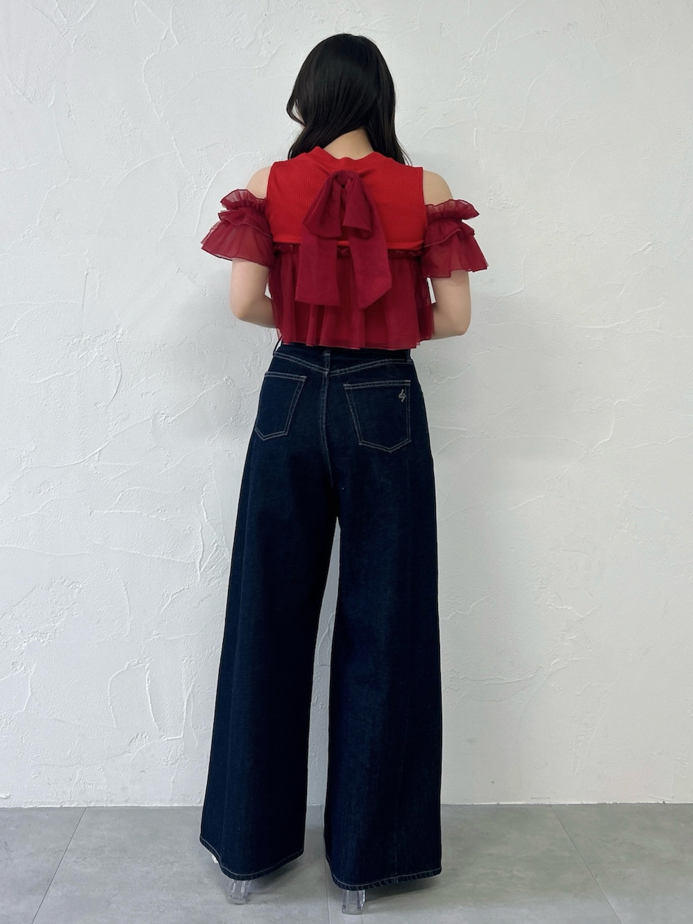 レッド系のTシャツ/カットソー、ブルー系のデニムパンツを着用したレディースの春コーディネートの5枚目の写真