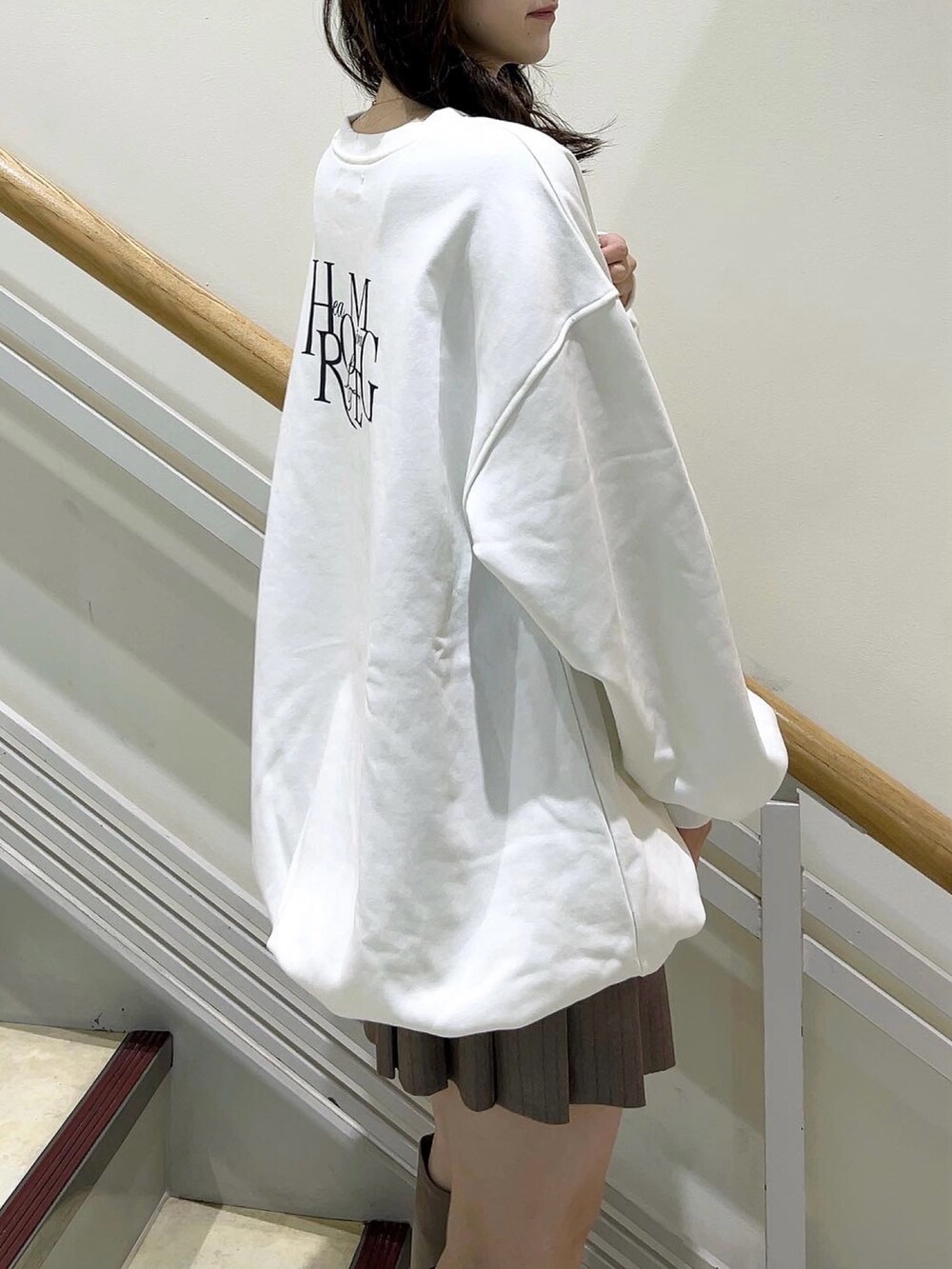 ホワイト系のTシャツ/カットソー、ベージュ系のスカート、ベージュ系のブーツを着用したレディースの冬コーディネートの10枚目の写真