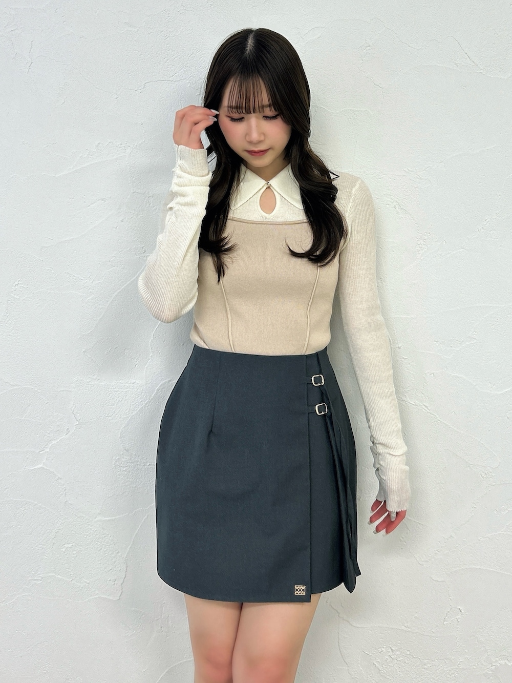 グレー系のスカート、ブラック系のブーツ、ベージュ系のニット/セーターを着用したレディースの春コーディネートの8枚目の写真