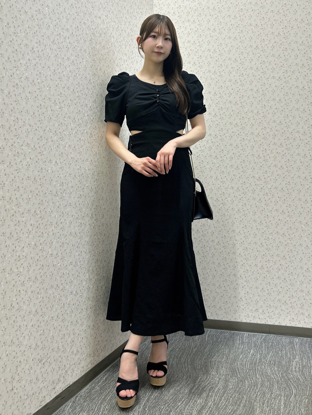 ブラック系のワンピース、ブラック系のハンドバッグ、ブラック系のサンダルを着用したレディースの夏コーディネートの2枚目の写真