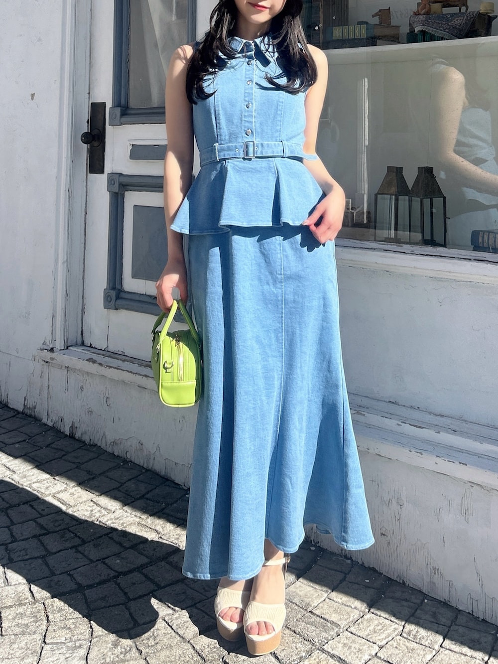 ブルー系のワンピース、ホワイト系のサンダル、イエロー系のハンドバッグを着用したレディースの春コーディネートの3枚目の写真