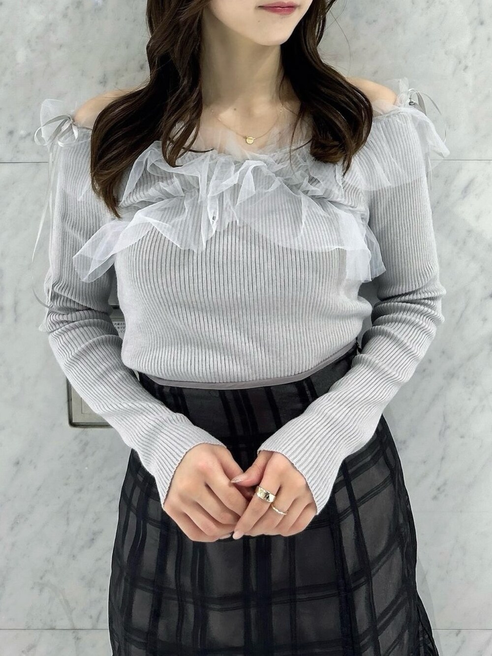 ブラック系のスカート、ブラック系のパンプス、グレー系のニット/セーターを着用したレディースの秋コーディネートの6枚目の写真