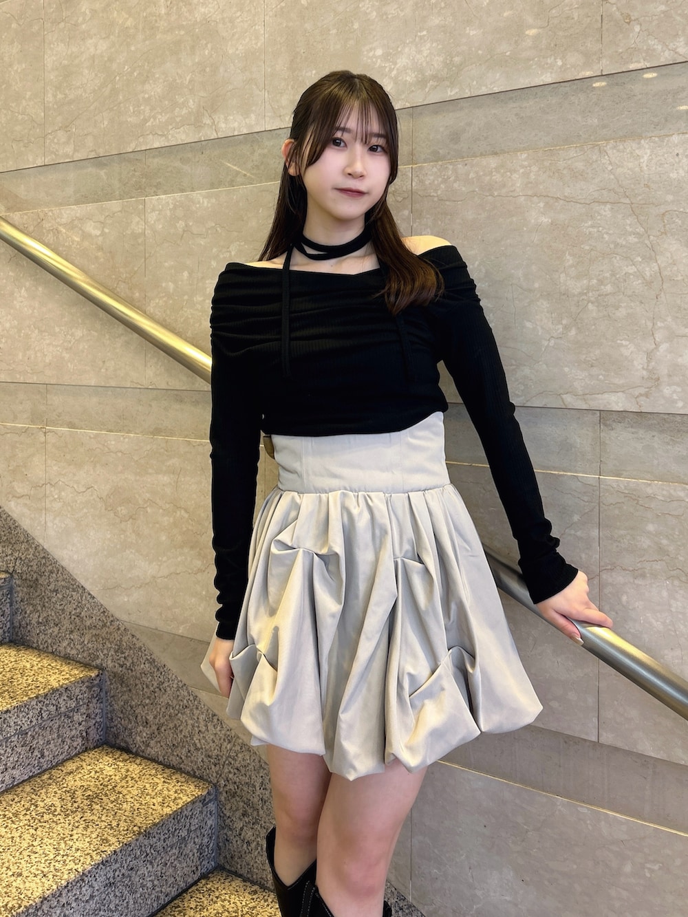 ブラック系のTシャツ/カットソー、ベージュ系のスカート、その他のブーツを着用したレディースの冬コーディネートの6枚目の写真