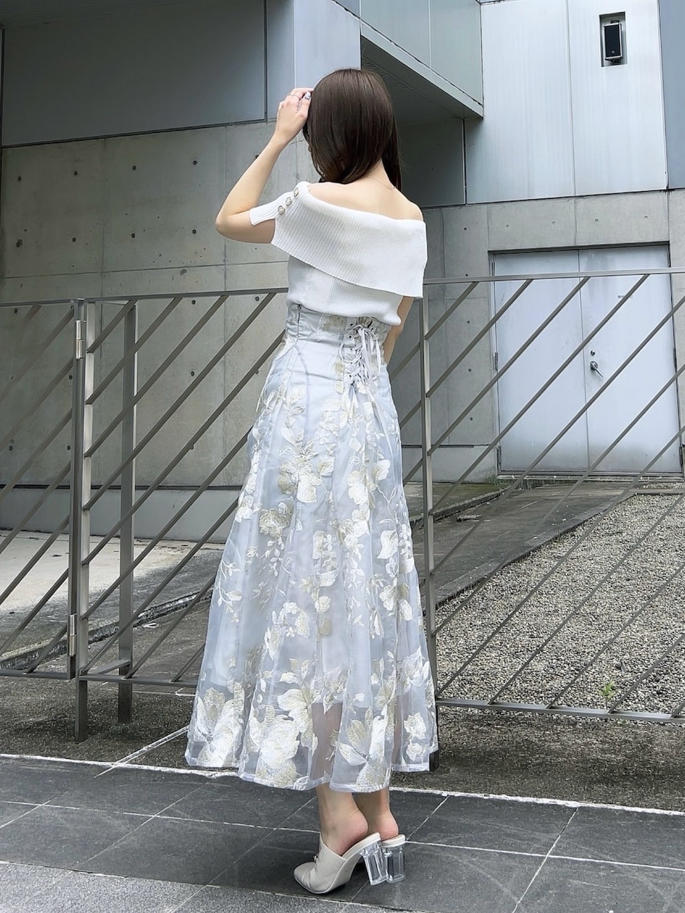 ホワイト系のニット/セーター、グレー系のスカート、ホワイト系のパンプスを着用したレディースの夏コーディネートの6枚目の写真