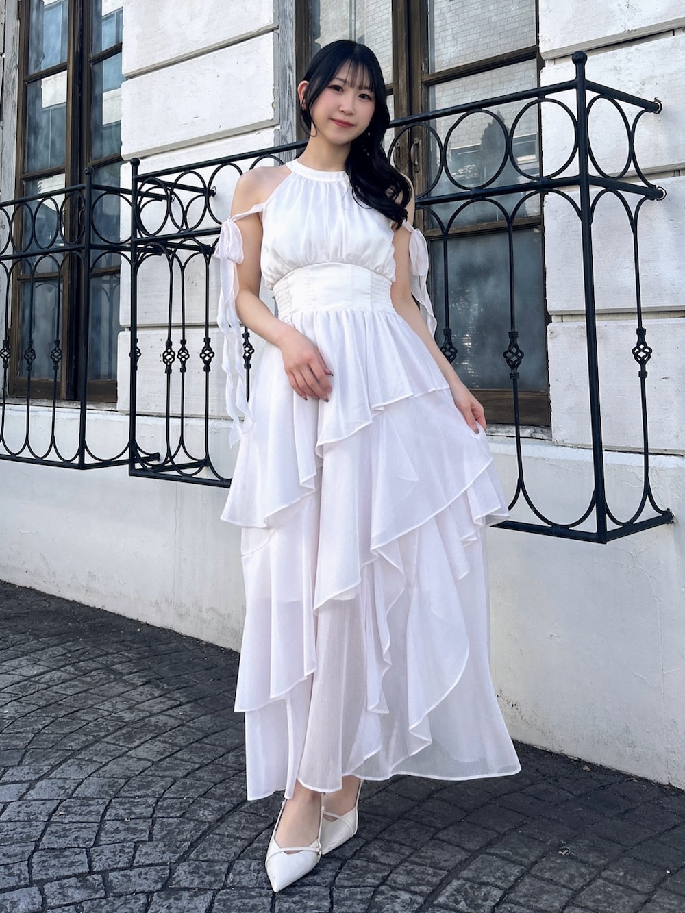 ピンク系のワンピースを着用したレディースの春コーディネートの2枚目の写真