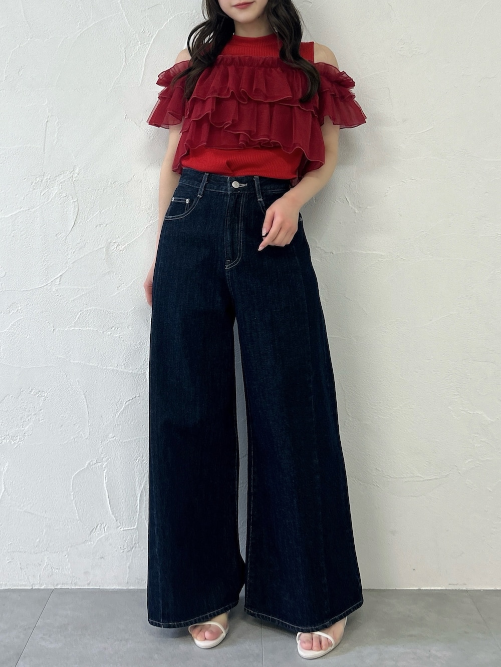 レッド系のTシャツ/カットソー、ブルー系のデニムパンツを着用したレディースの春コーディネートの3枚目の写真