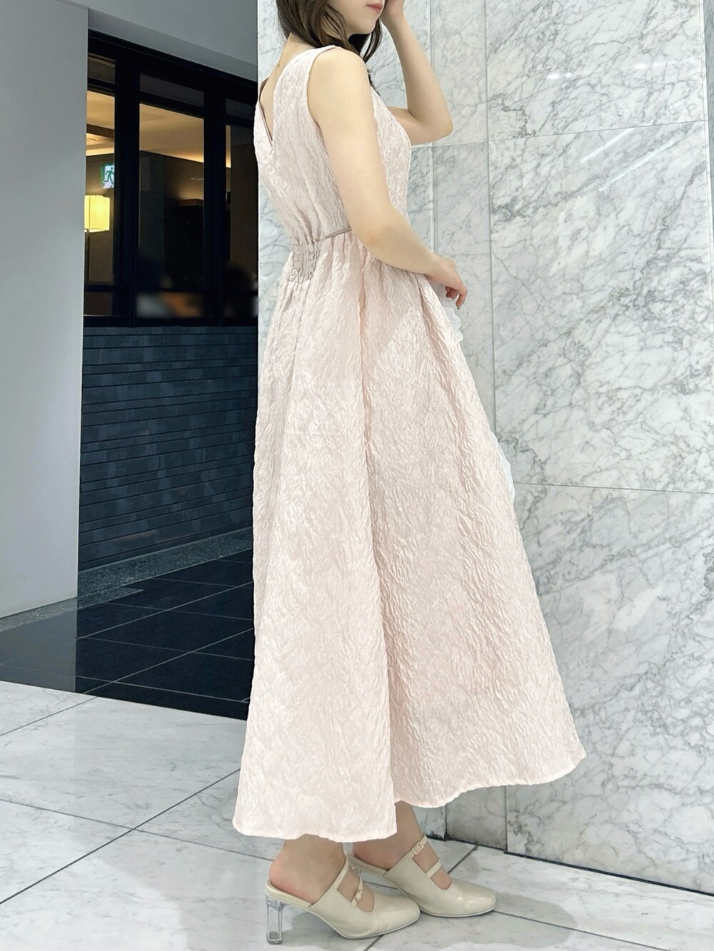 ホワイト系のパンプス、ホワイト系のハンドバッグ、ピンク系のドレスを着用したレディースの夏コーディネートの5枚目の写真