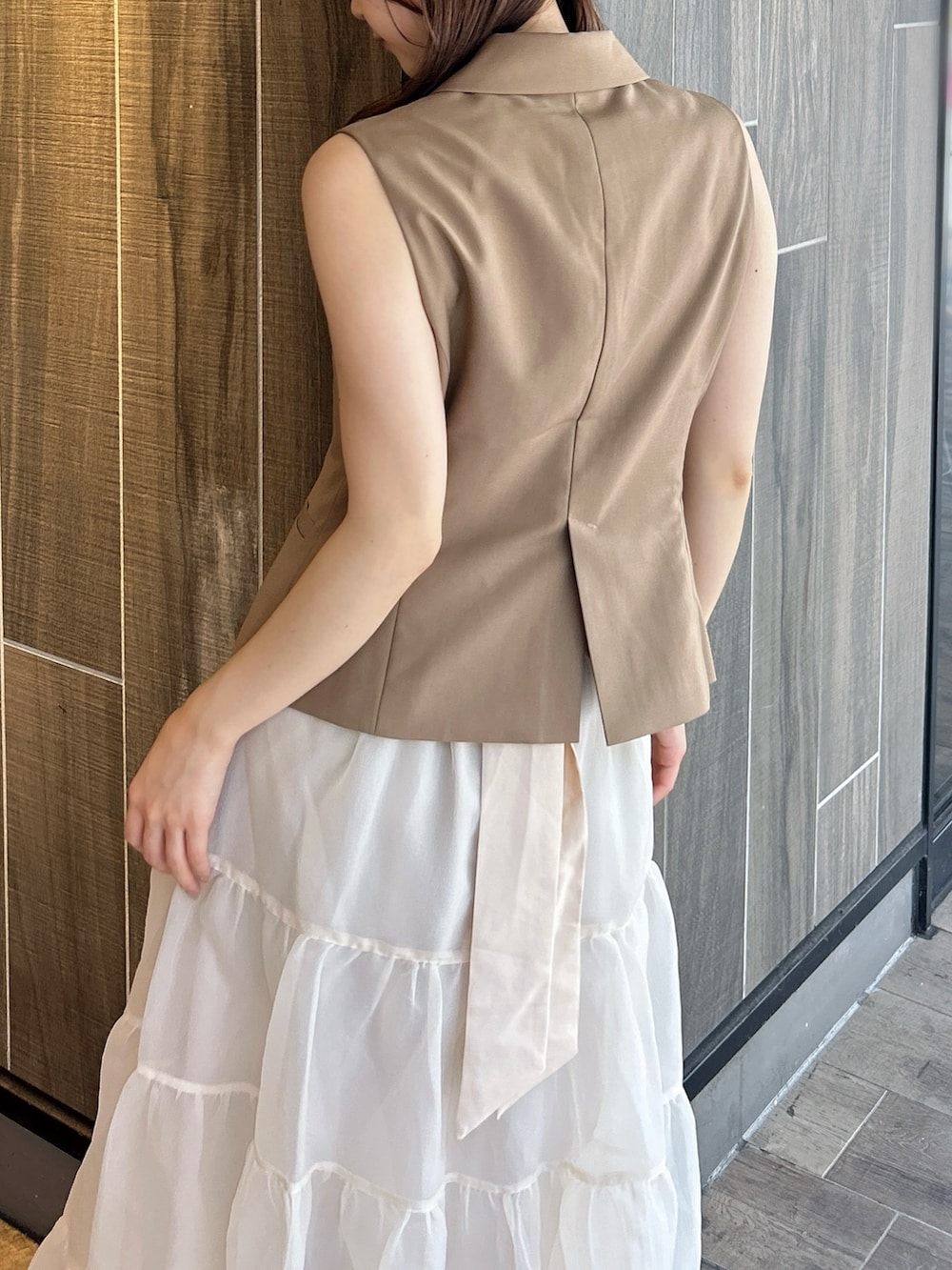 ブラウン系のベスト、ホワイト系のTシャツ/カットソー、ベージュ系のスカートを着用したレディースの秋コーディネートの10枚目の写真