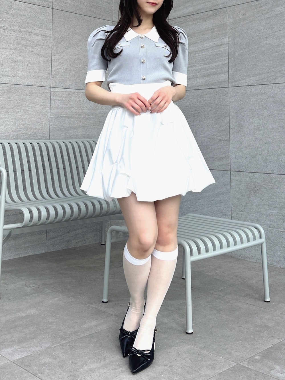 グレー系のニット/セーター、ホワイト系のスカートを着用したレディースの冬コーディネートの2枚目の写真