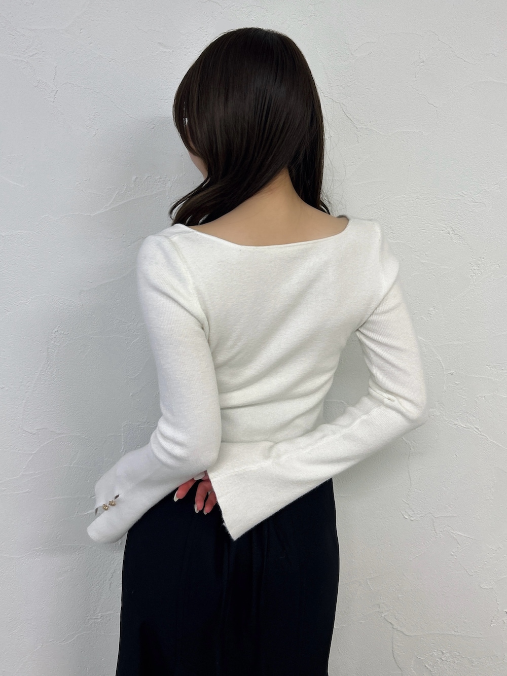 ホワイト系のニット/セーター、ブラック系のスカート、ブラック系のサンダルを着用したレディースの春コーディネートの7枚目の写真