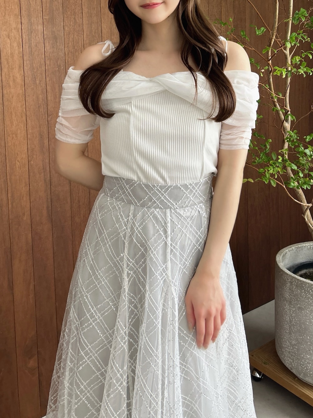 グレー系のスカート、ホワイト系のパンプス、ブラウン系のショルダーバッグを着用したレディースの夏コーディネートの7枚目の写真