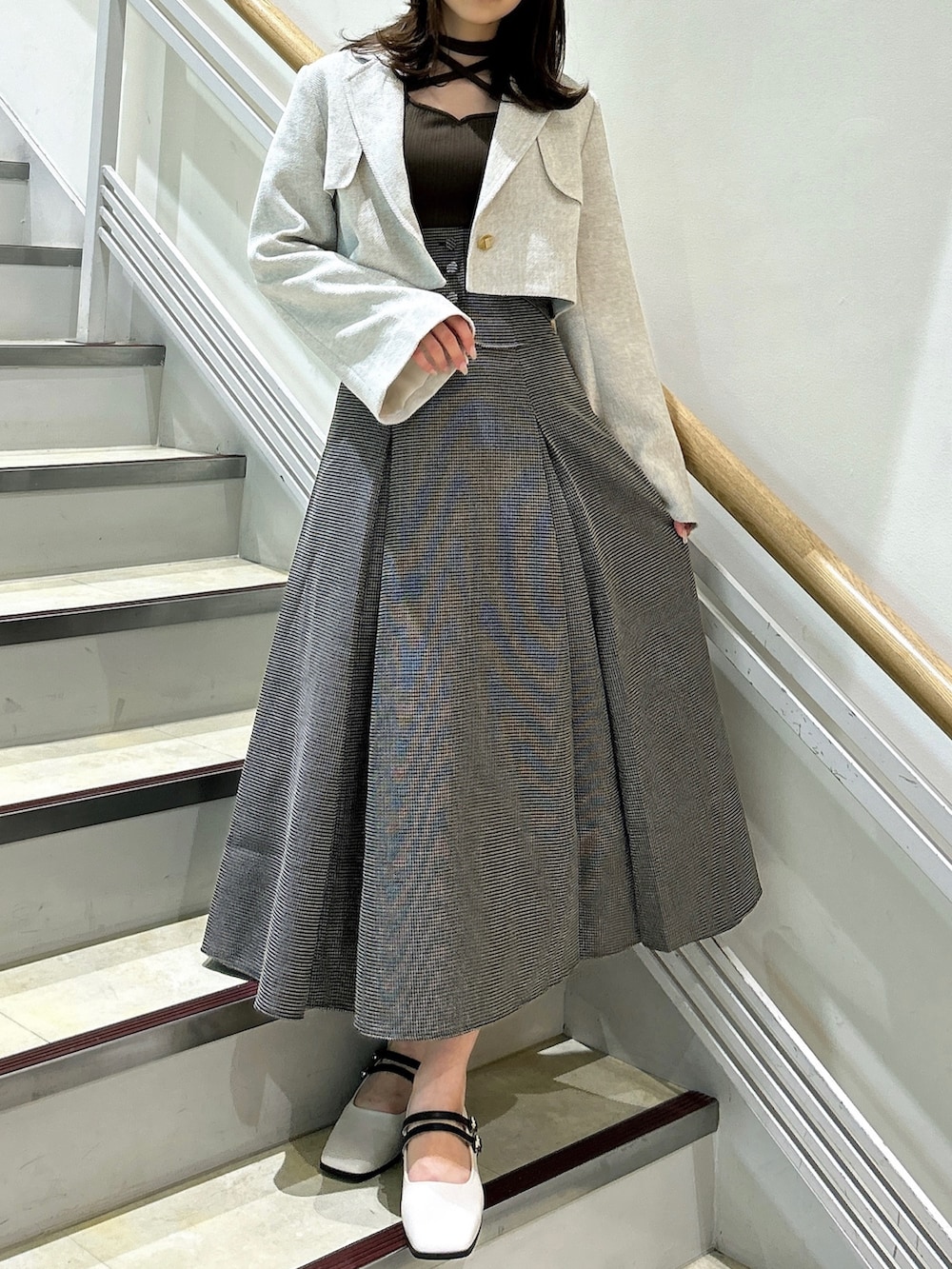 ブラウン系のワンピース、ホワイト系のテーラードジャケット、ベージュ系のパンプスを着用したレディースの秋コーディネートの3枚目の写真