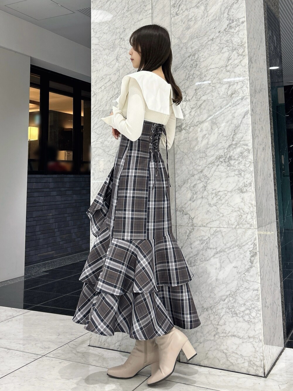 ホワイト系のワンピース、ベージュ系のブーツを着用したレディースの冬コーディネートの5枚目の写真