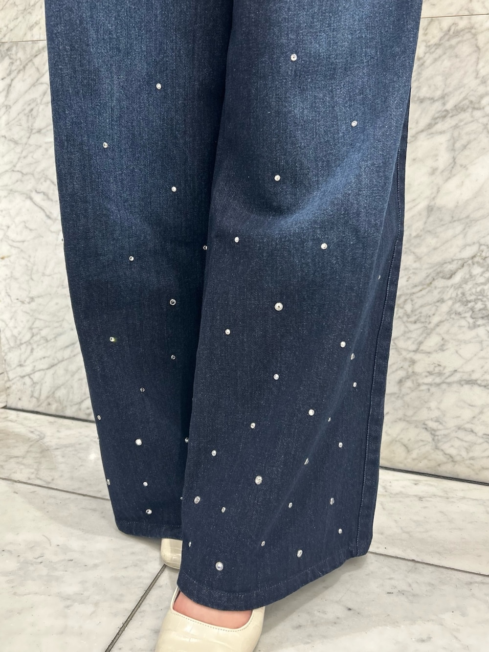 ブルー系のニット/セーター、ブルー系のデニムパンツ、ホワイト系のパンプスを着用したレディースの夏コーディネートの10枚目の写真