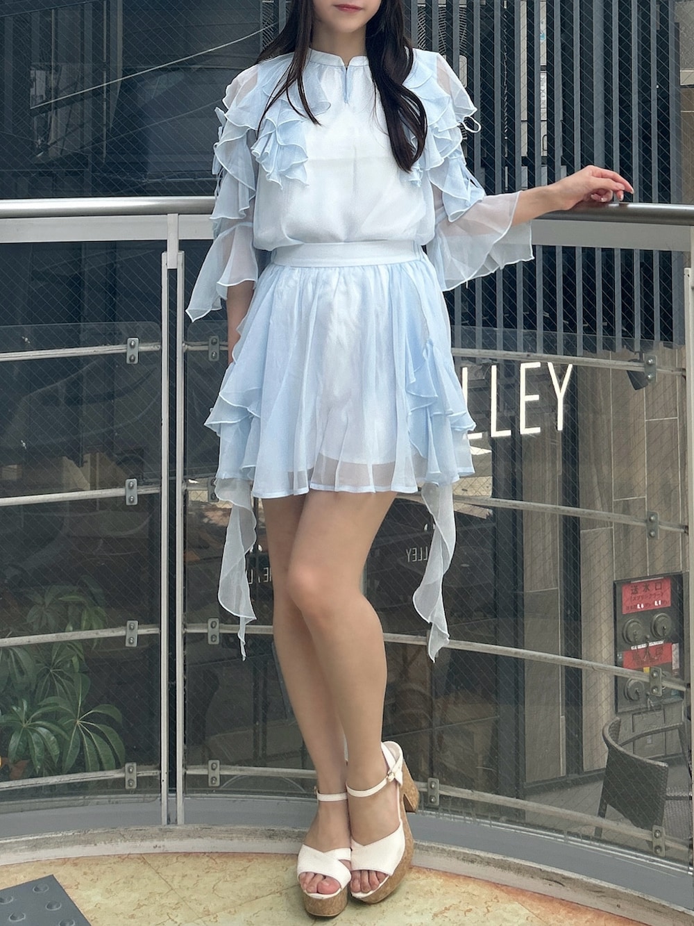 ブルー系のシャツ/ブラウス、ブルー系のスカート、ホワイト系のサンダルを着用したレディースの秋コーディネートの2枚目の写真