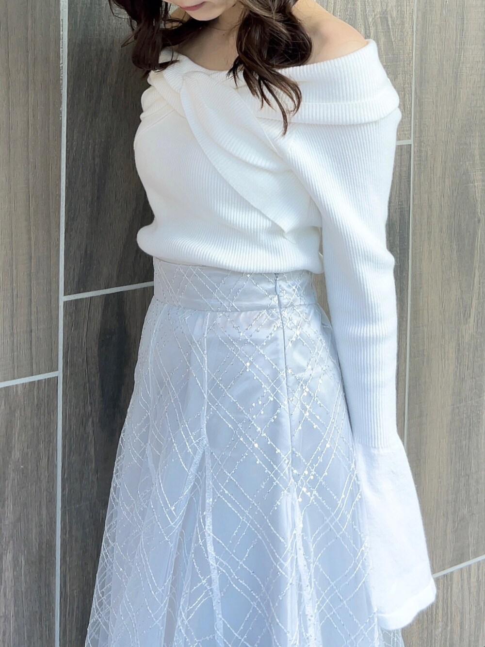 ホワイト系のニット/セーター、グレー系のスカート、ホワイト系のブーツを着用したレディースの冬コーディネートの9枚目の写真