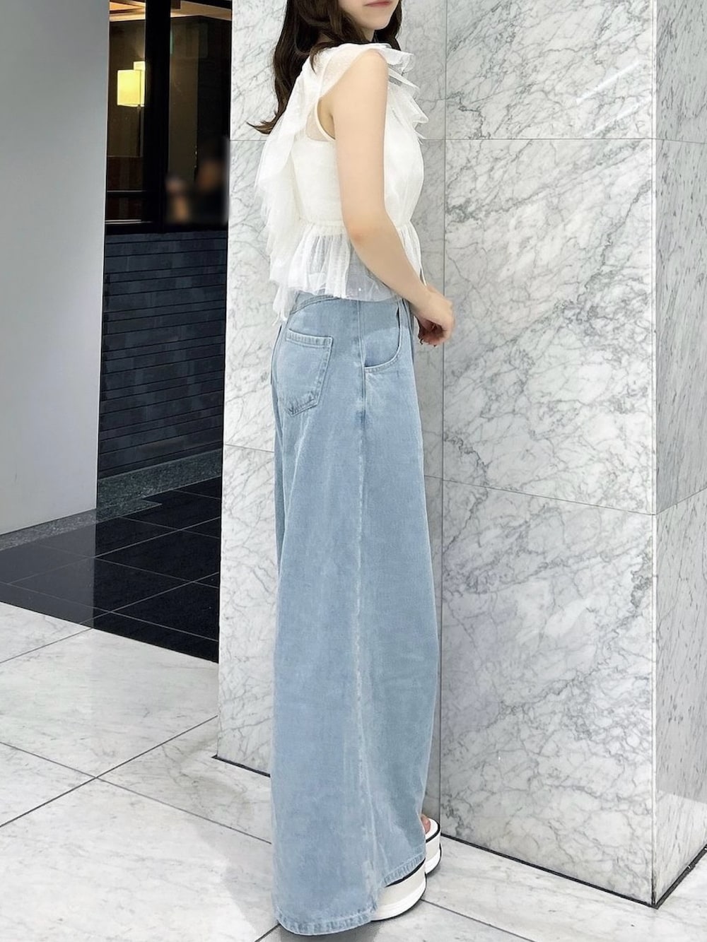 ホワイト系のタンクトップ、ホワイト系のキャミソール、ブルー系のデニムパンツを着用したレディースの夏コーディネートの3枚目の写真