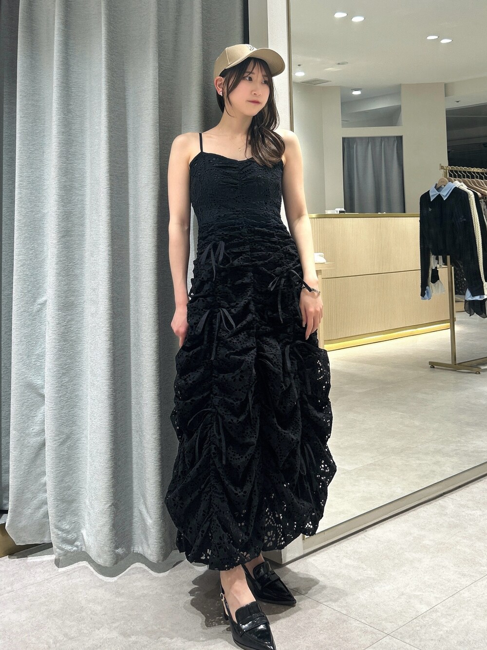 ブラック系のワンピース、ブラック系のローファー、ベージュ系のキャップを着用したレディースの春コーディネートの3枚目の写真