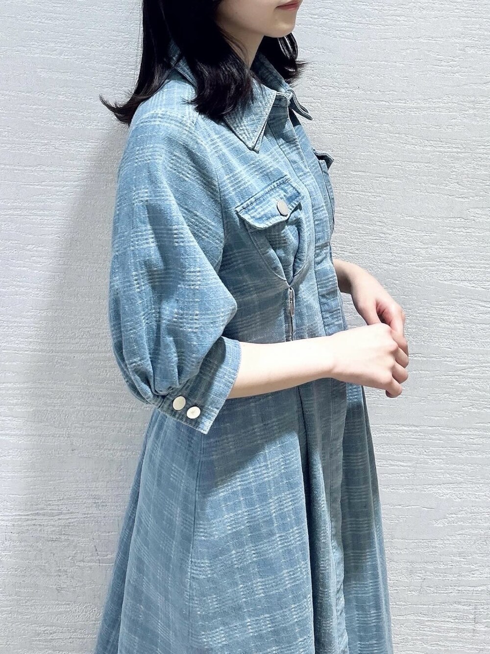 ブルー系のワンピース、ホワイト系のブーツを着用したレディースの冬コーディネートの9枚目の写真