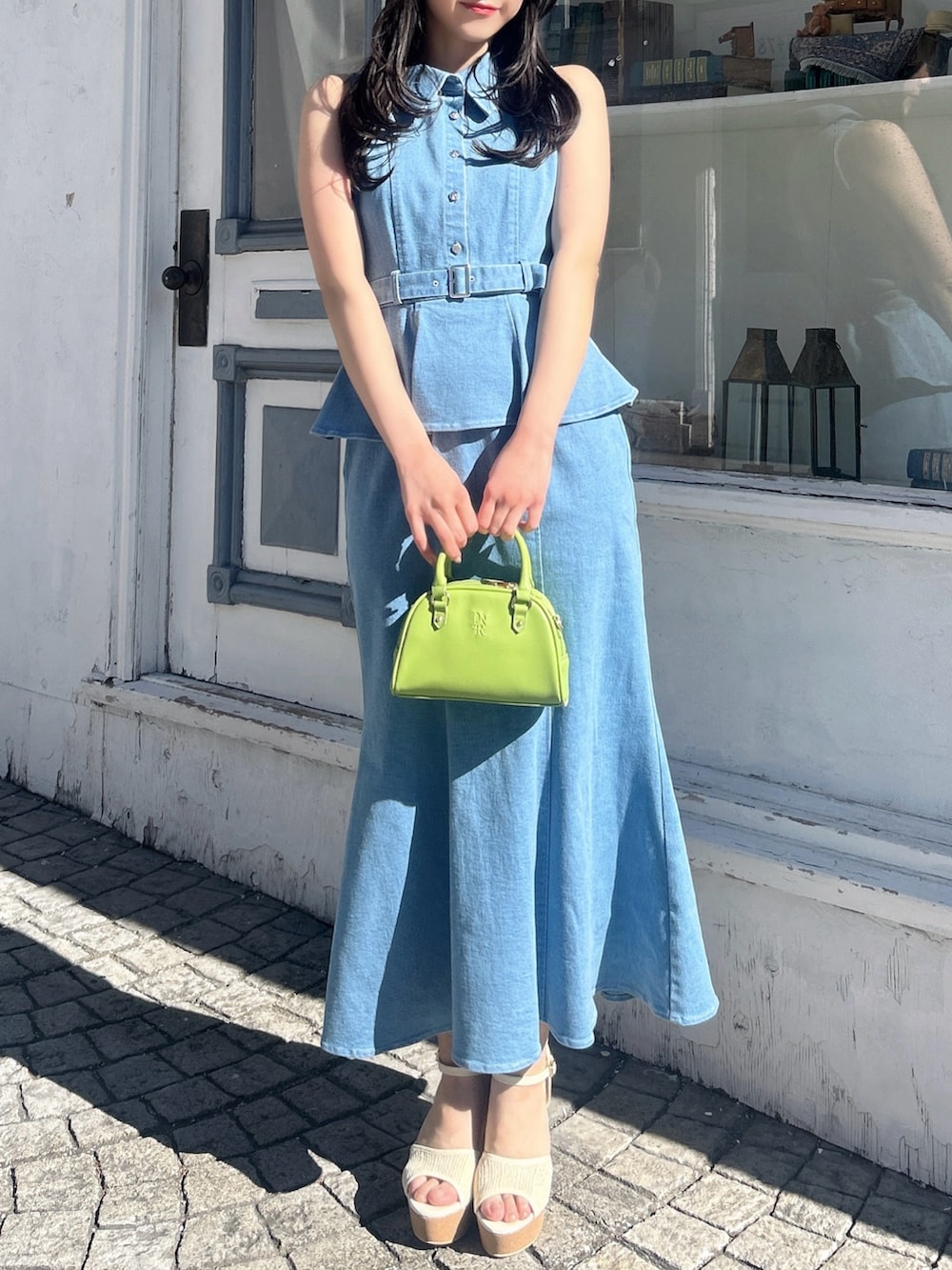 ブルー系のワンピース、ホワイト系のサンダル、イエロー系のハンドバッグを着用したレディースの春コーディネートの2枚目の写真