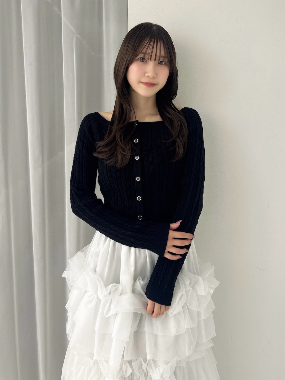 ブラック系のニット/セーター、ホワイト系のスカート、ブラック系のサンダルを着用したレディースの冬コーディネートの8枚目の写真