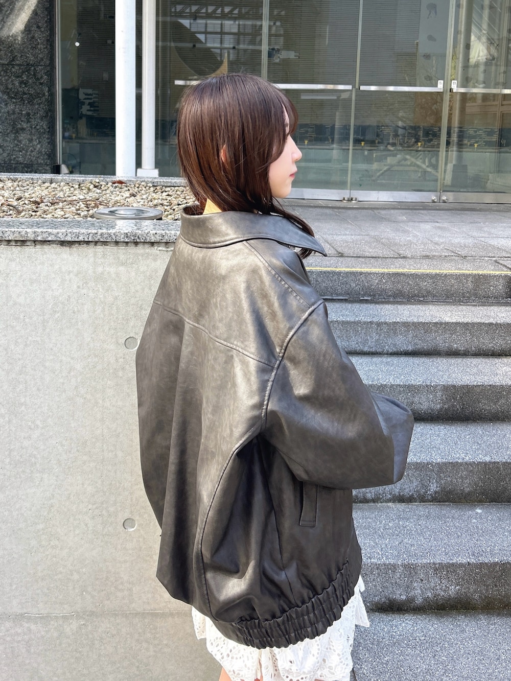 ブラック系のブルゾン、ホワイト系のワンピースを着用したレディースの冬コーディネートの8枚目の写真