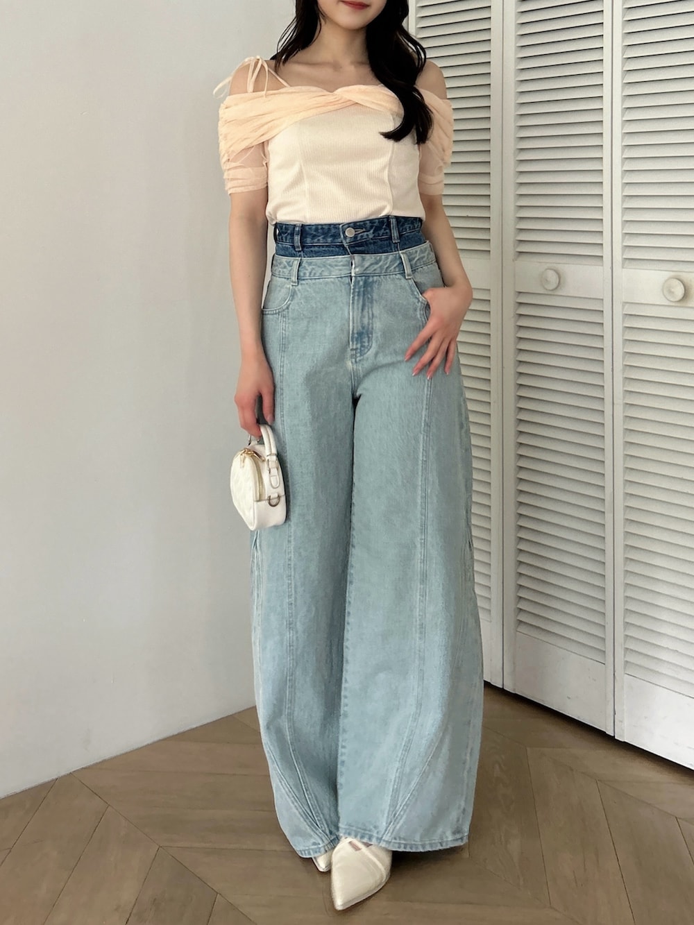オレンジ系のTシャツ/カットソー、ホワイト系のパンプス、ブルー系のデニムパンツを着用したレディースの夏コーディネートの2枚目の写真