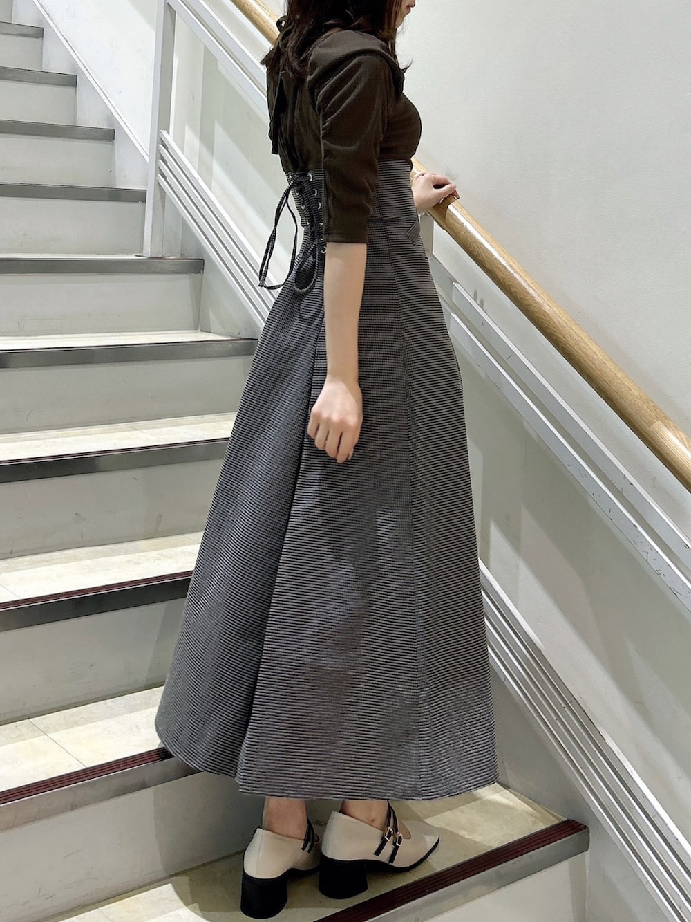 ブラウン系のワンピース、ベージュ系のパンプスを着用したレディースの秋コーディネートの4枚目の写真