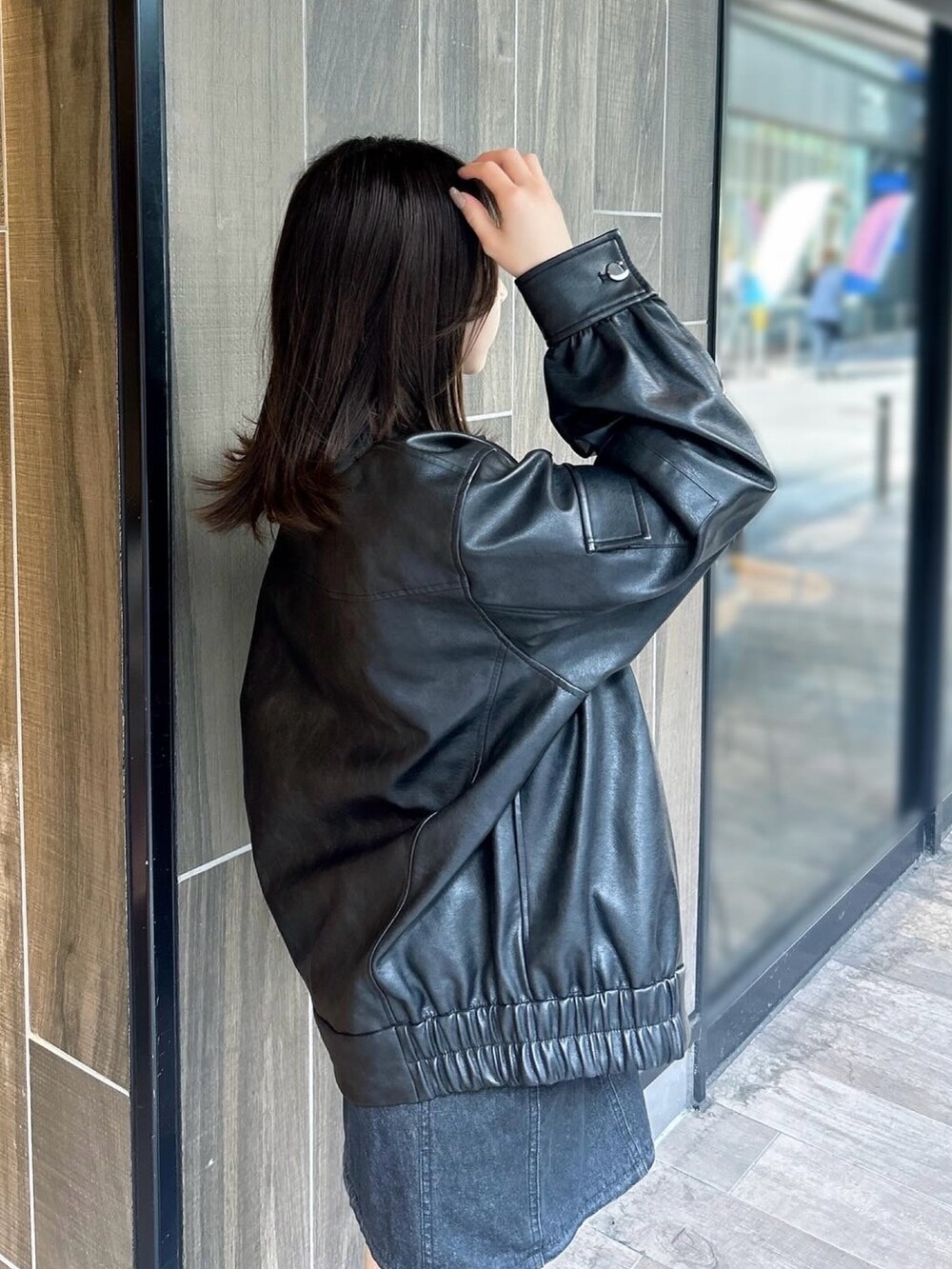 ブラック系のブルゾン、ブラック系のワンピース、ブラック系のブーツを着用したレディースの春コーディネートの6枚目の写真