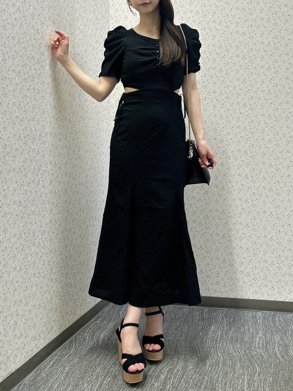 ブラック系のワンピース、ブラック系のハンドバッグ、ブラック系のサンダルを着用したレディースの夏コーディネートの3枚目の写真