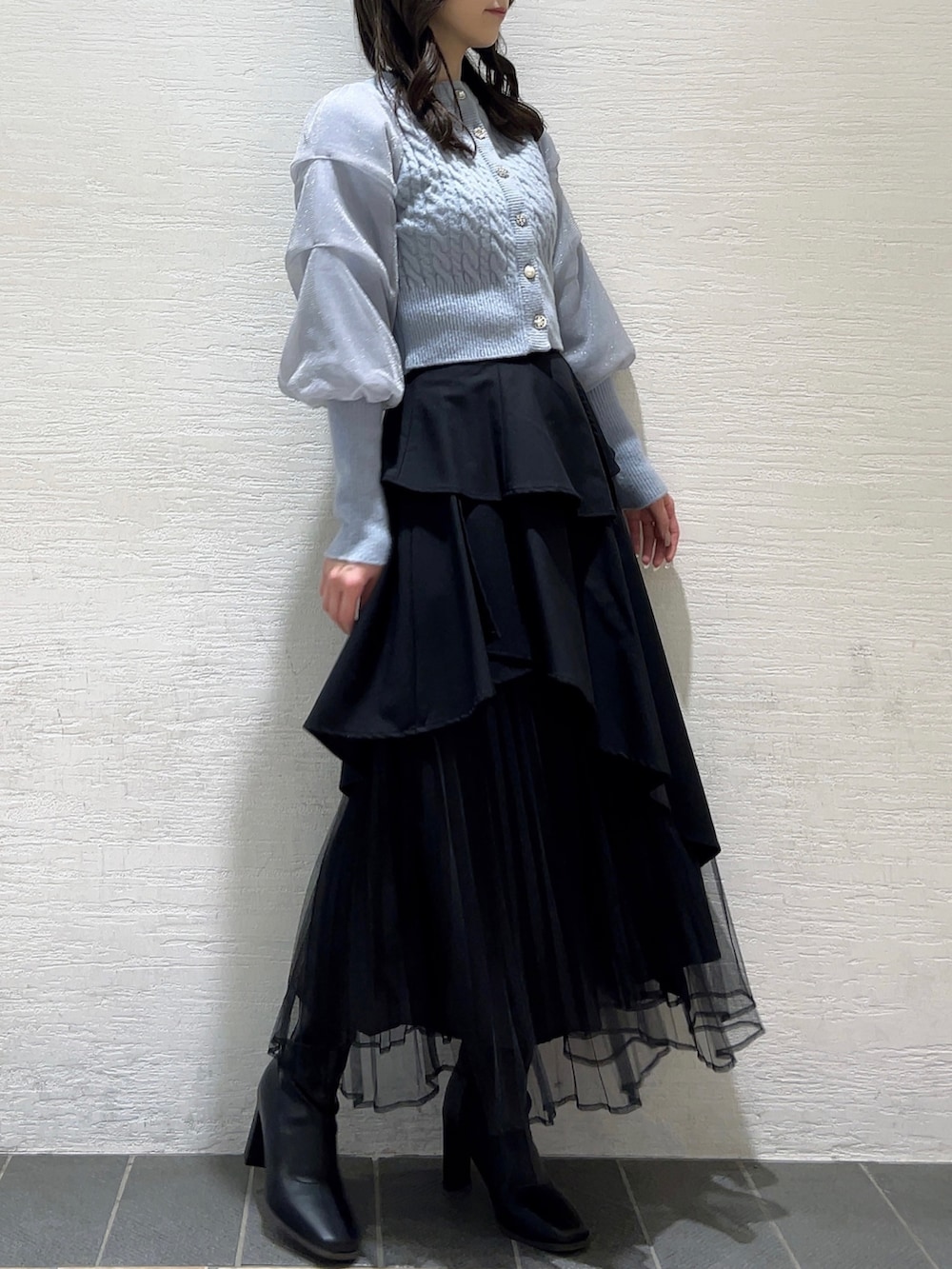 ブルー系のカーディガン/ボレロ、ブラック系のスカート、ブラック系のブーツを着用したレディースの冬コーディネートの4枚目の写真