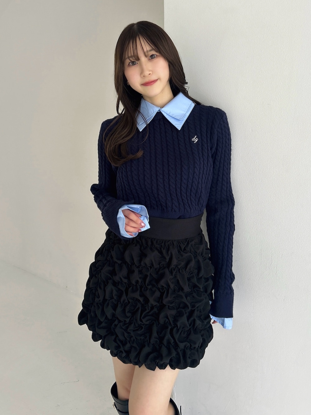 ブラック系のブーツ、ブラック系のスカート、ブルー系のニット/セーターを着用したレディースの冬コーディネートの10枚目の写真