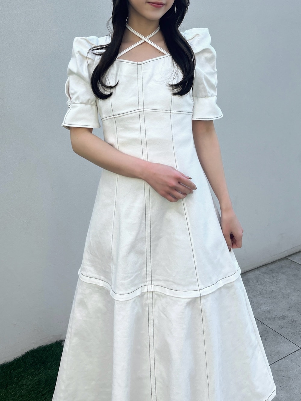 ホワイト系のワンピース、ホワイト系のサンダル、イエロー系のハンドバッグを着用したレディースの春コーディネートの6枚目の写真