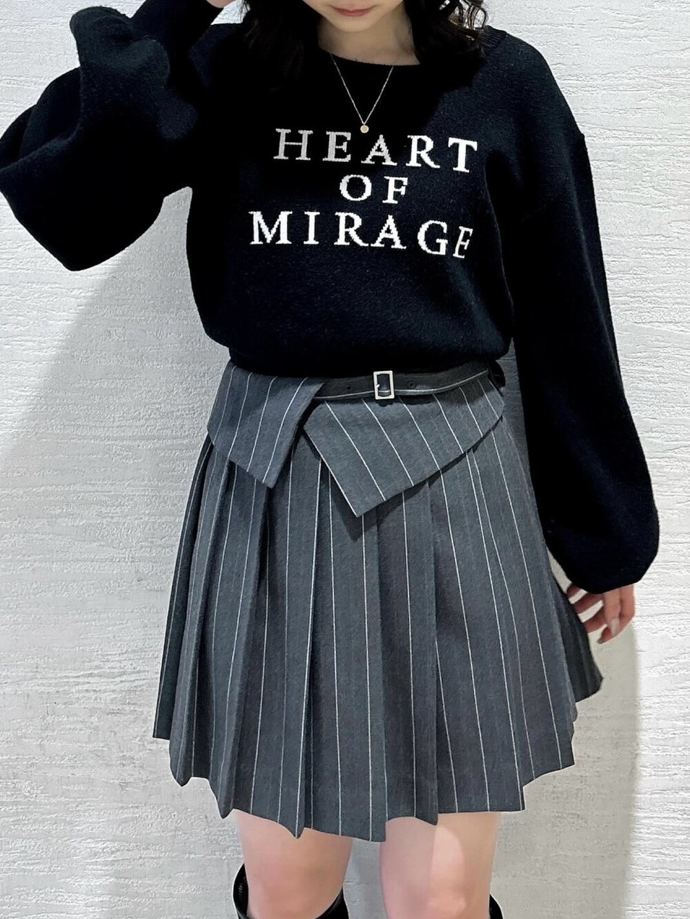 ブラック系のニット/セーター、グレー系のスカート、ブラック系のブーツを着用したレディースの春コーディネートの5枚目の写真