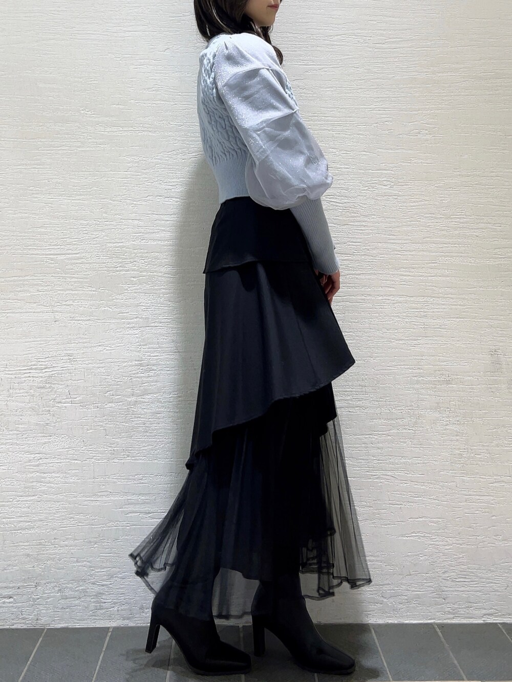 ブルー系のカーディガン/ボレロ、ブラック系のスカート、ブラック系のブーツを着用したレディースの冬コーディネートの5枚目の写真