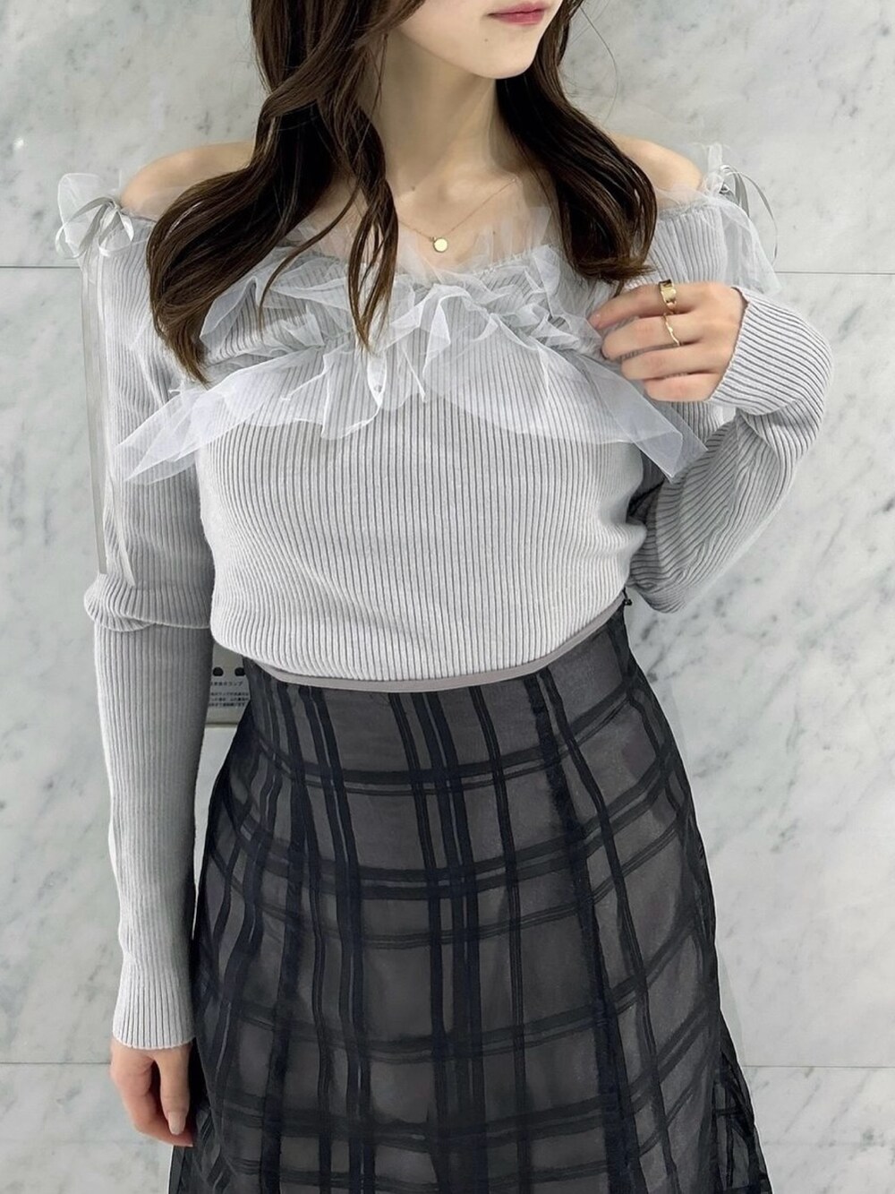 ブラック系のスカート、ブラック系のパンプス、グレー系のニット/セーターを着用したレディースの秋コーディネートの7枚目の写真