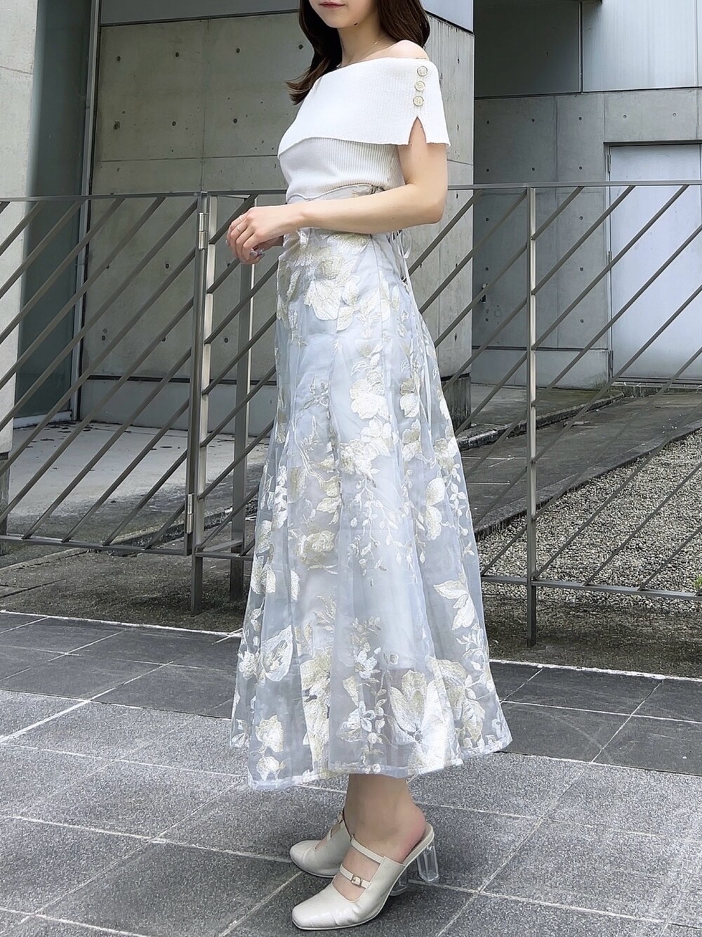 ホワイト系のニット/セーター、グレー系のスカート、ホワイト系のパンプスを着用したレディースの夏コーディネートの3枚目の写真