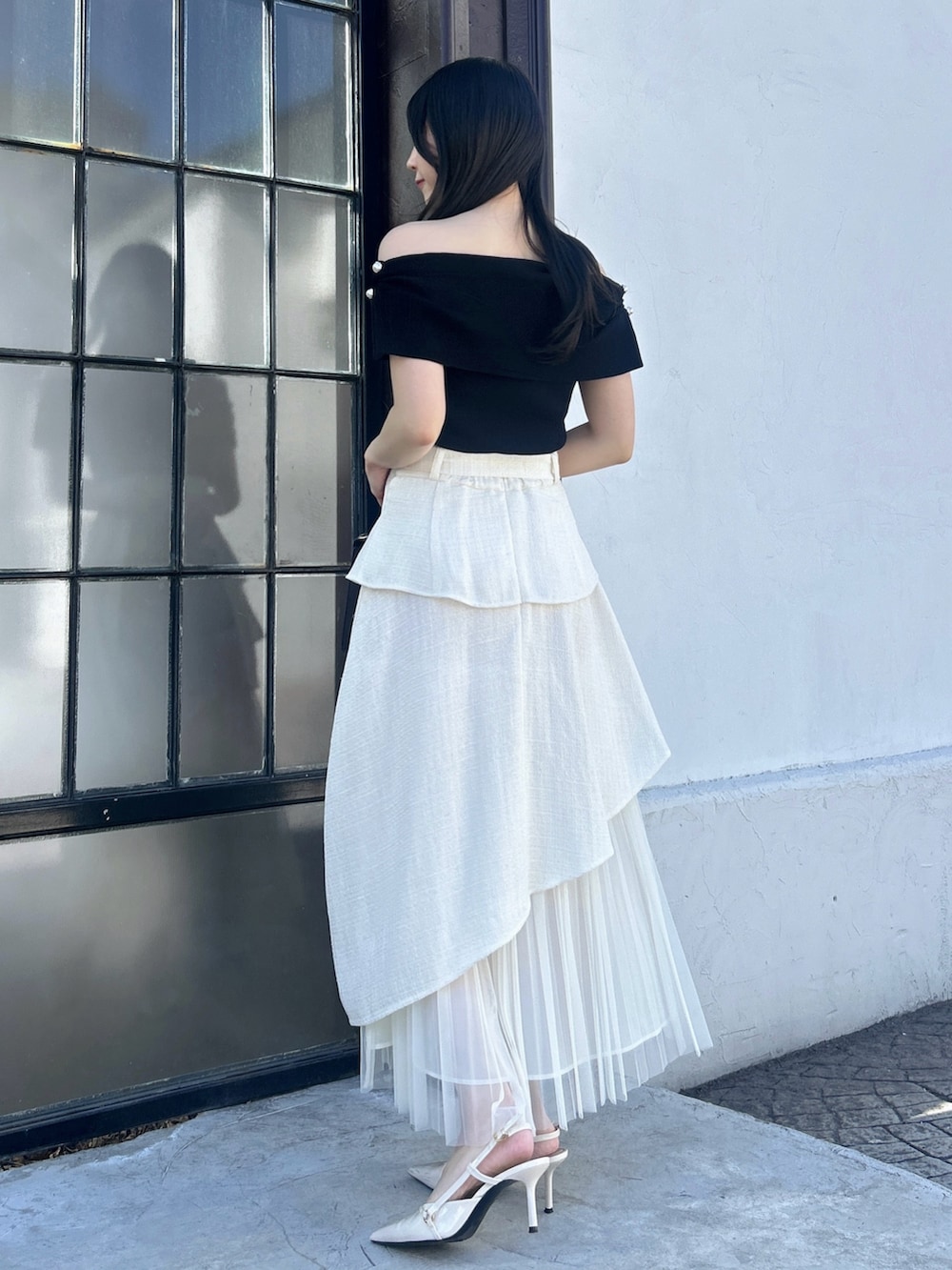 ホワイト系のスカート、ブラック系のニット/セーターを着用したレディースの冬コーディネートの3枚目の写真