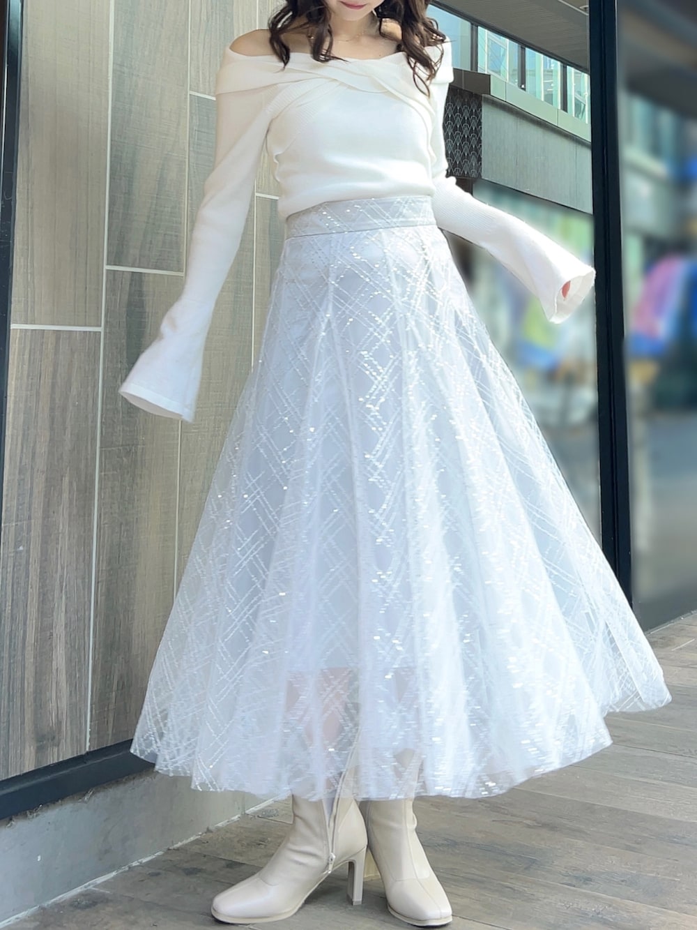 ホワイト系のニット/セーター、グレー系のスカート、ホワイト系のブーツを着用したレディースの冬コーディネートの4枚目の写真