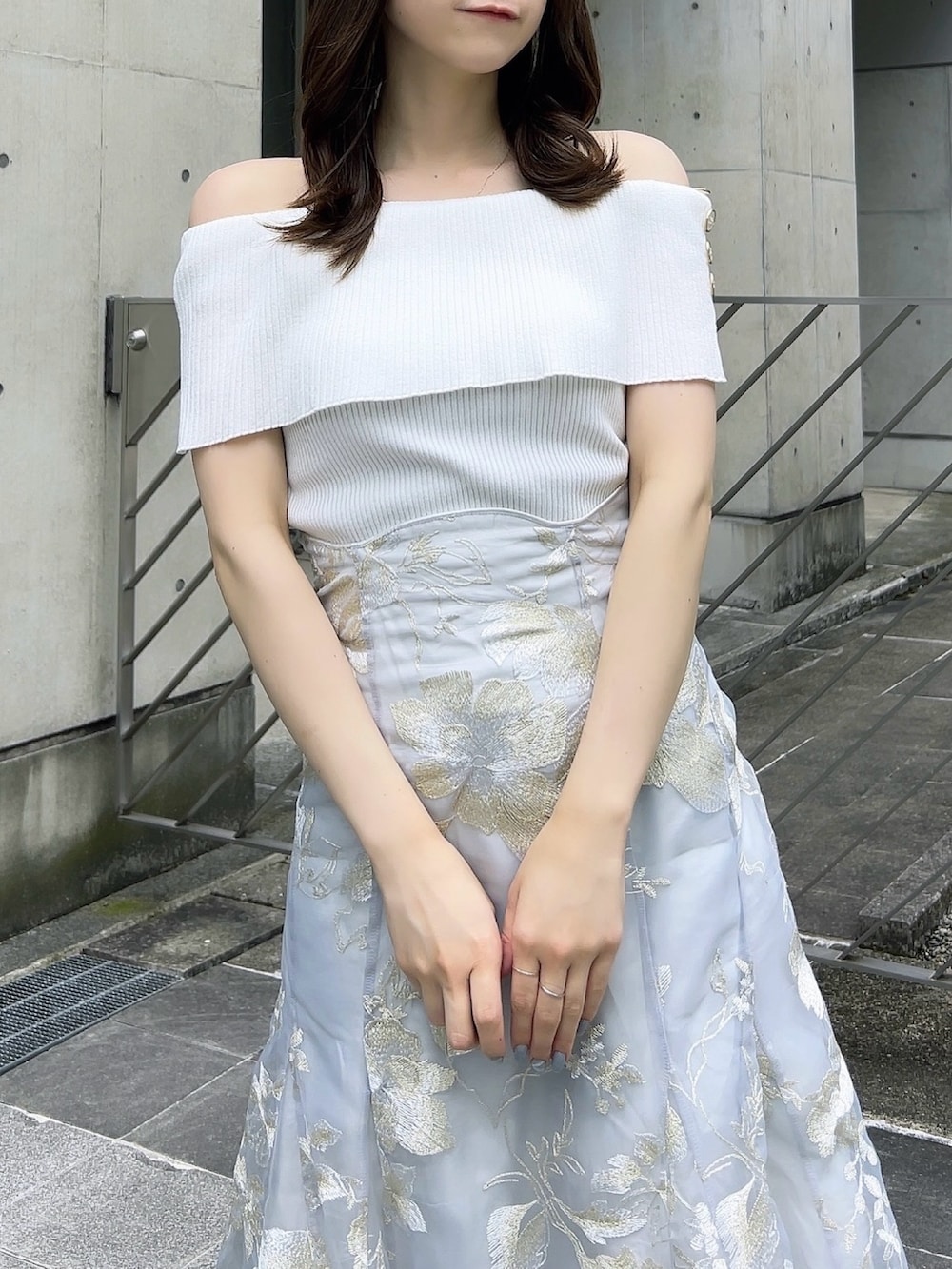 ホワイト系のニット/セーター、グレー系のスカート、ホワイト系のパンプスを着用したレディースの夏コーディネートの8枚目の写真
